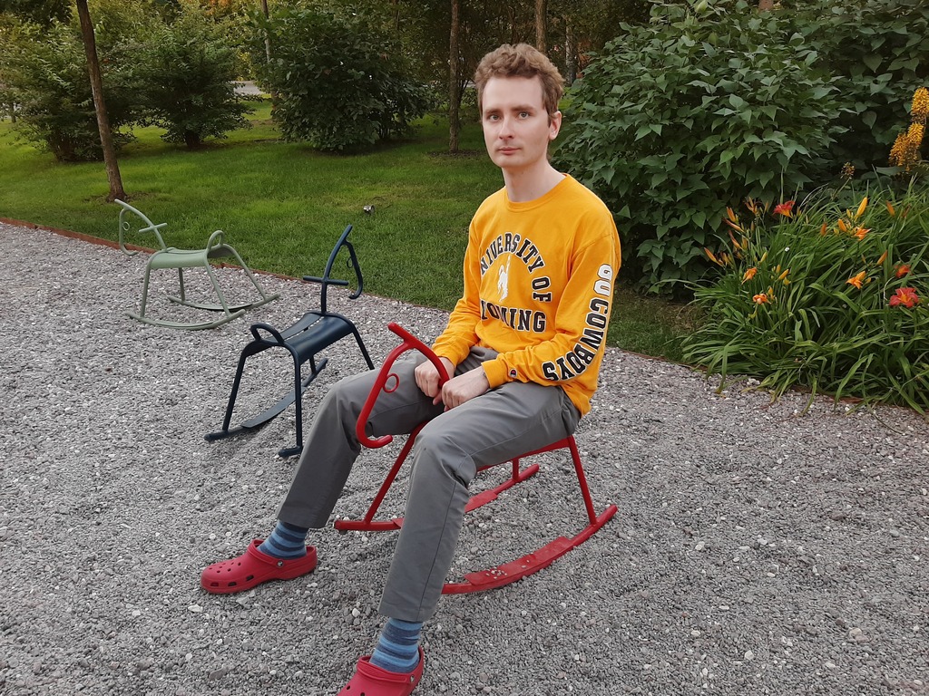 Grigory Sarnitsky sitting on a playground horse in 2019